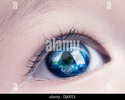 License available at MaximImages.com - Closeup of a child's blue eye with the Earth globe, world map reflecting in it Stock Photo