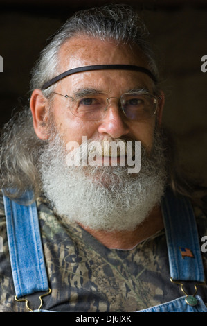 Portrait of Man with Full Gray Beard, Long Hair and Bib-and-brace Denim Overalls Stock Photo