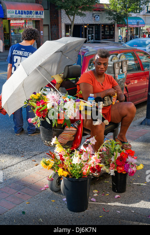 Woman with amputated forearm selling flowers on sidewalk, Stock Photo