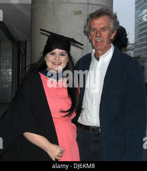 London England Young Woman At Graduation Ceremony Wearing Mortar Board And Graduation Robes Standing With Her Father Stock Photo