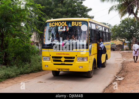 Indian school bus going through a rural indian village. Andhra Pradesh, India Stock Photo