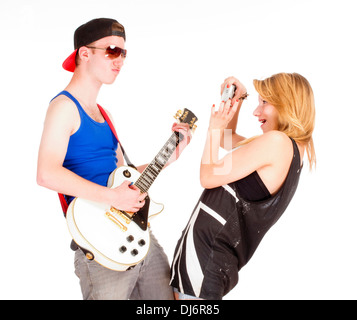 Teenage Couple - Girl Taking Pictures of her Boyfriend with Guitar - Isolated on White Stock Photo