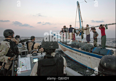 US Navy Sailors with the visit, board, search and seizure team from the USS Mason pull alongside a fishing dhow in a rigid hull inflatable boat to check if assistance is needed November 20, 2013 in the Gulf of Aden. The Navy routinely checks small boats in the region for pirates. Stock Photo