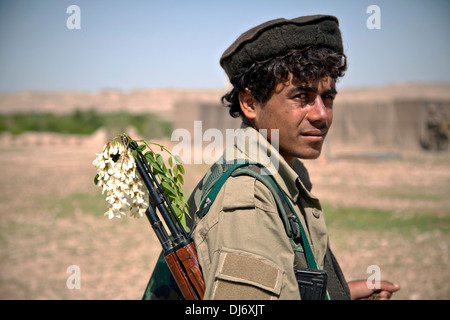 A young Afghan Local Policeman with flowers in his AK-47 rifle at a checkpoint March 30, 2013 in Helmand province, Afghanistan.