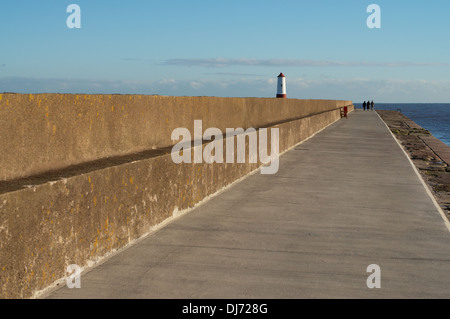 Group of three people walking along the pier Berwick upon Tweed, Northumberland, England, UK Stock Photo