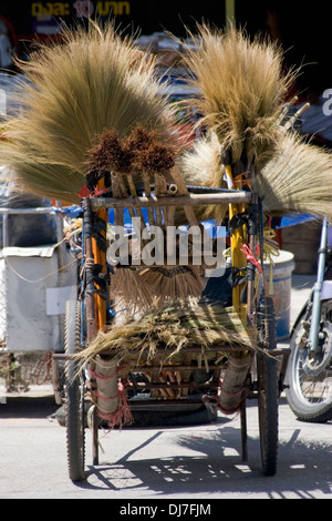 A cart filled with handmade brooms that are for sale rests on a city street in Khon Kaen, Thailand. Stock Photo