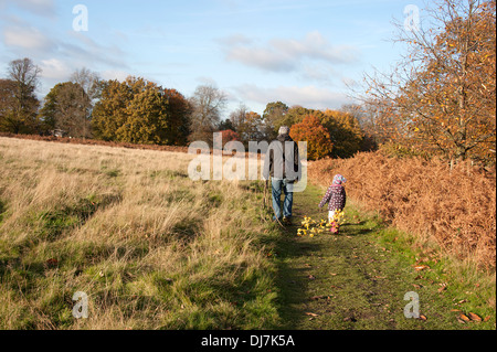 Happy dad carries serious podgy cute son. Stock Photo