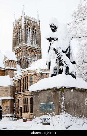 Statue of Poet Laureate Alfred Lord Tennyson and his dog, covered in snow, in the grounds of Lincoln Cathedral in Lincolnshire Stock Photo