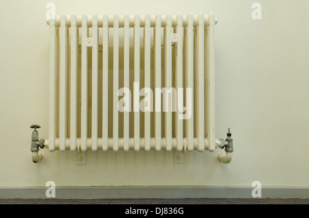 old style fashioned convection radiator without any thermostatic heat valves not green friendly with partial leak on tap valve Stock Photo