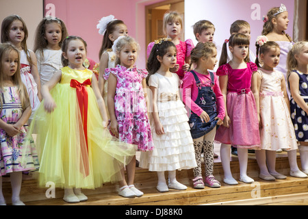 Russian children kindergarten. Kids singing the songs from the stage for parents. Russia Stock Photo