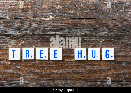 Letters lying on wood spelling the words Tree Hug Stock Photo