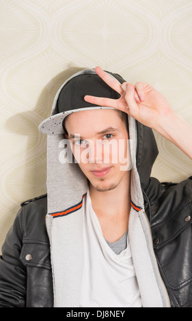 Young man with cool attitude making a peace sign with his hand Stock Photo