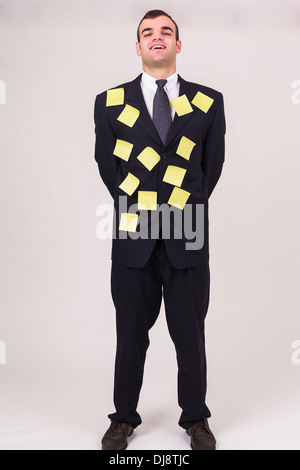 Smiling businessman with sticky notes on his suit Stock Photo