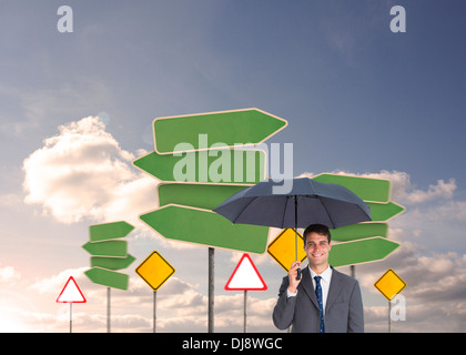 Happy businessman holding umbrella Stock Photo