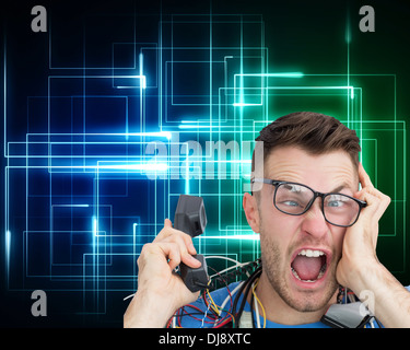 Frustrated computer engineer screaming while on call Stock Photo