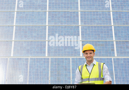 Worker standing under shade by wind turbine Stock Photo