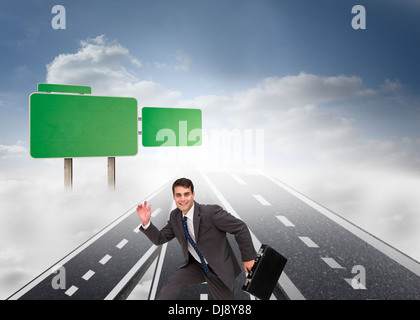 Happy businessman holding a briefcase and running Stock Photo