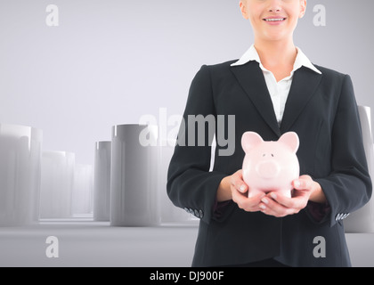 Businesswoman holding piggy bank Stock Photo