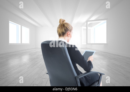 Composite image of businesswoman sitting on swivel chair with tablet Stock Photo