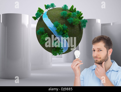 Composite image of handsome model holding a bulb Stock Photo