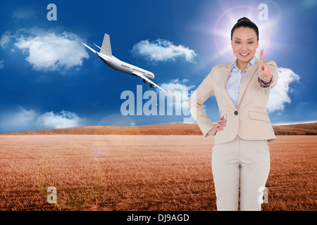 Composite image of smiling asian businesswoman pointing Stock Photo