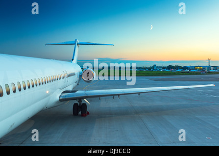 Plane at the airport at sunset Stock Photo