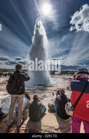 Tourist taking pictures of Strokkur Gesyer erupting, Iceland Stock Photo