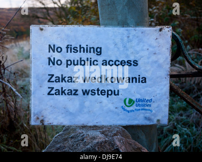 No Fishing and no public access sign in English and Polish. Walkerwood Reservoir Stalybridge, Cheshire, UK. Stock Photo