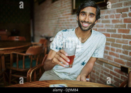 Asian man drinking beer in pub Stock Photo