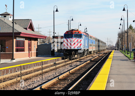 Train arriving at suburban commuter train station. Stock Photo