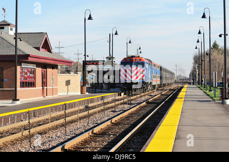 Train arriving at suburban commuter train station. Stock Photo