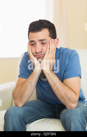 Casual sad man sitting on couch Stock Photo