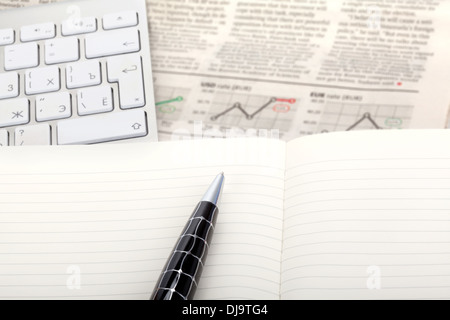 Business photo: fresh newspaper with stock index overview and open note with keyboard Stock Photo