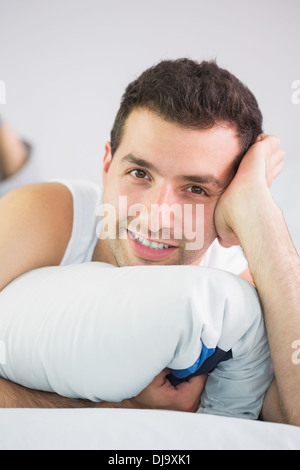 Smiling handsome man lying in bed looking at camera Stock Photo