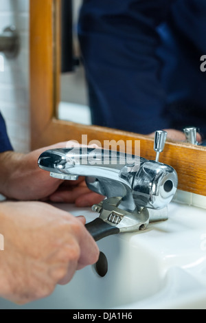 Close up of plumber checking tap Stock Photo