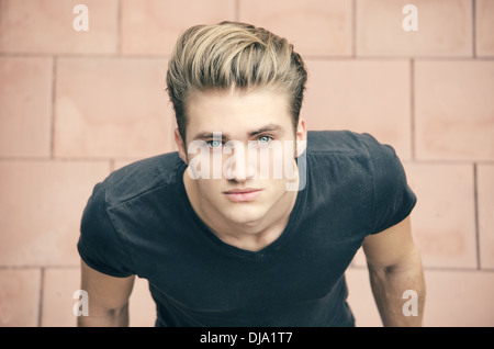 Attractive blond young man shot from above, looking up towards camera Stock Photo