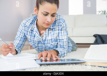 Concentrated pretty student using her tablet for assignments Stock Photo