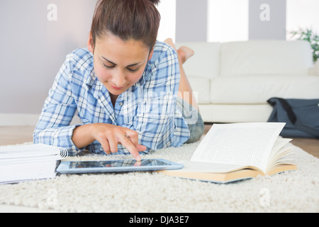 Pretty young student using her tablet for doing homework Stock Photo