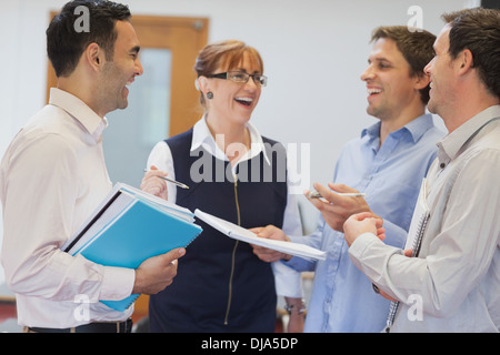 Group of mature students standing in classroom chatting Stock Photo
