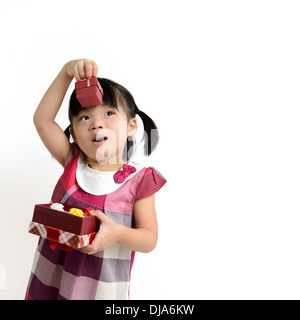 Portrait of little girl lifting up gift box Stock Photo