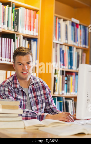 Handsome smiling student using computer Stock Photo