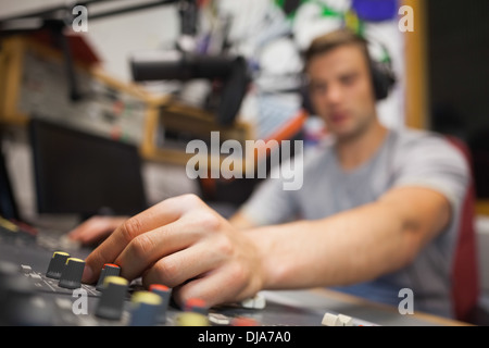 Handsome radio host moderating touching switch Stock Photo