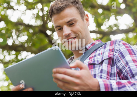 Handsome happy student using tablet Stock Photo