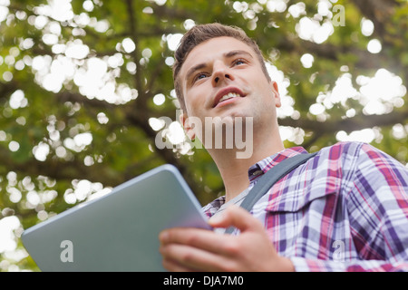 Handsome smiling student using tablet Stock Photo
