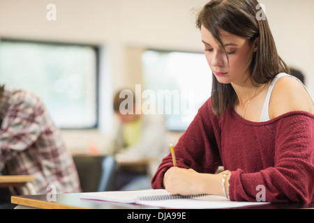 Student writing notes in the classroom Stock Photo