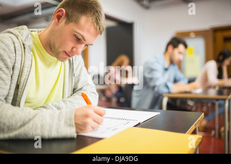Students writing notes in classroom Stock Photo
