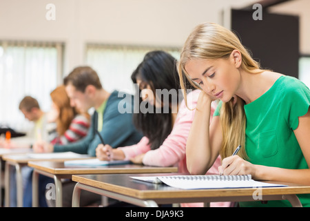 Young students writing notes in classroom Stock Photo