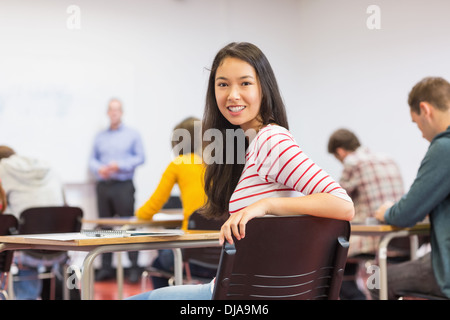 Female with blurred teachers students in classroom Stock Photo