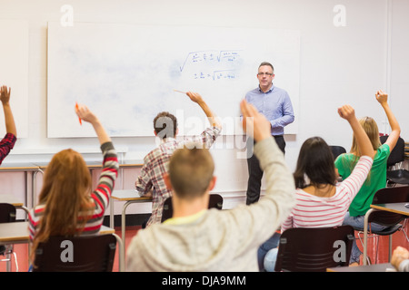 Students raising hands in the classroom Stock Photo