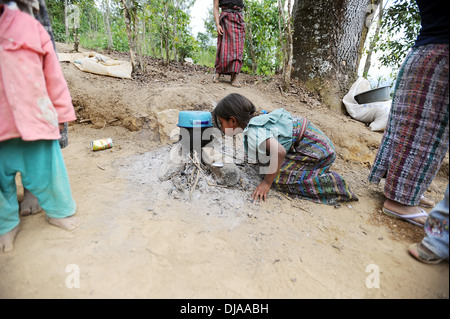 A Guatemala indigenous girl makes open fire for cooking in Aqua Escondida in Solola, Guatemala. Stock Photo